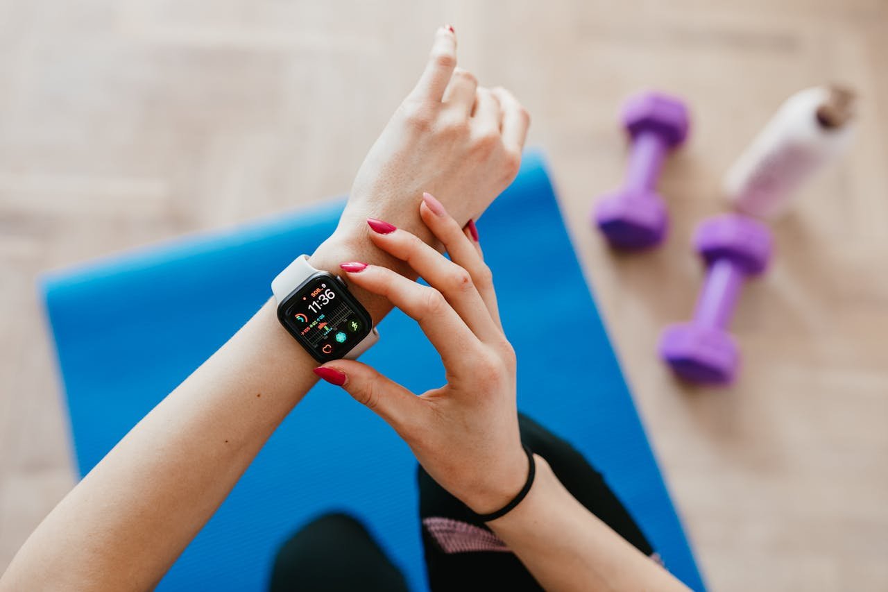 hero-img A woman checks fitness data on her smartwatch during a workout at home.